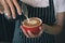 Closeup image of female barista hands pouring milk and preparing fresh latte, coffee artist and preparation concept, red cup