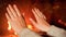 Closeup image of female hands warming at burning firepalce