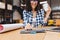 Closeup image hand of young brunette woman designing on table in library surround work stuff. Laptop, creative work