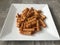 Closeup image of leftover tortiglioni pasta fried with an egg