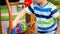 Closeup image of little boy playing on the playground and rotating wooden rings. Smarts child solving puzzle and