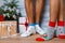 Closeup image of male feet in woolen socks on a wooden background. Hairy men`s legs in New Year`s socks.