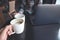 Closeup image of two business woman clinking white coffee mugs while drinking coffee in cafe with laptop