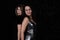 Closeup image of a two pretty women on a modern black tube background