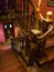 Closeup image of wooden staricase with red carpet and carved handrails at old hotel or restaurant