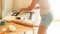 Closeup image of young housewife putting cut dough pieces on baking pan. Woman baking cookies at home