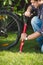 Closeup image of young man using air pump to fix flat bicycle tyre