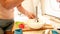 Closeup image of young woman mixing ingredients in bowl while cooking. Photo of girl using electric blender while making