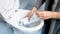 Closeup image of young woman pouring detergent from bottle in toilet