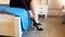 Closeup image of young woman sitting on bed at hotel and taking off high heels shoes