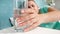 Closeup image of young woman taking glass of water with dissolved aspirin from bedside table