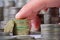 Closeup of an index finger taps on a stack of british pound coin