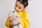 Closeup indoor image of a smiling happy child playing at home with a little dog. Cute little girl cares about the puppy. Adorable