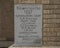 Closeup of an information plaque of engraved stone in a brick wall of the old Commissioner`s Court Building in McKinney, Texas.
