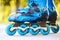 Closeup of inline roller skates with blue wheels.