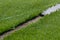 Closeup installation of football field with artificial turf with grass. Close up of line of an artificial football field. Details