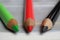 Closeup of isolated colorful green, red and black crayons on wood background - kenya coalition concept