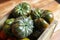 Closeup of isolated group dark black beef cabomar tomatoes in rustic wood box, brown wooden planks background