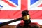 Closeup of isolated judge wood gavel with blurred english flag background focus on hammer head