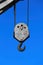 Closeup of isolated old metal empty crane hook against deep blue cloudless sky - Germany