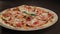 Closeup Italian Pizza on White Plate against Black Table