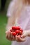 Closeup of a ittle blond girl holding cherries in her hands