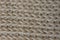 Closeup of ivory handmade knitted fabric ribbing pattern