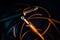 Closeup of Jack Connectors on Quarter Inch Cord in Front of Tangled Wire on Teal Backdrop with Orange Lighting