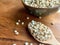 Closeup of Job`s Tears or Millet in a bowl and on a wooden spoon placed on a wooden cutting board