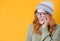 Closeup jolly young woman, isolated on yellow background. Laughing woman with eyes closed