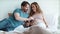 Closeup joyful pregnant couple talking in bed. Happy pregnant couple kissing