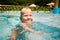 closeup kid\'s funny face of with screwed up eyes over pool water