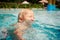 closeup kid\'s funny face of with screwed up eyes over pool water