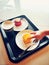 Closeup of kids child hand trying to steal tasty cakes from plate on tray. Impatient person taking food dessert on dish.