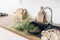 Closeup of kitchen interior. White brick wall, metro tiles, wooden countertops with chopping boards. Cow parsley plants