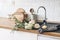 Closeup of kitchen interior. White brick wall, metro tiles, wooden countertops with kitchen utensils. Roses flowers in