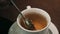 Closeup of lady pouring sugar while preparing hot tea cup