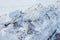 Closeup of large chunks of dirty snow, from a snowplow, on the street. Chunks of dirty snow on the side of the road