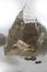 Closeup of a large crystal of transparent quartz standing on a blurred white background