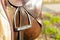 Closeup leather cowboy saddles hanging on the railing