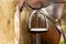 Closeup leather cowboy saddles hanging on the railing