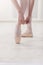 Closeup legs of ballerina puts on pointe ballet shoes