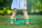 Closeup of legs of school girl in rubber boots and different colorful books on green grass. first day to school or