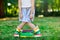 Closeup of legs of school girl in rubber boots and different colorful books on green grass. first day to school or