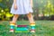 Closeup of legs of school girl in rubber boots and different colorful books on green grass. first day to school or