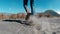 Closeup legs of woman walking in a volcanic dusty desert near beautiful Mount Bromo in East Java