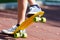 Closeup of the legs and yellow skateboard. Boy rising a board on two wheels, focus on skate.