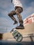 Closeup of the legs of a young skateboarder falling off the board after a jump