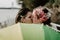 Closeup of a lesbian pair kissing each other and holding a rainbow umbrella on the bridge