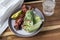 Closeup of the lettuce wraps with bacon and avocado on a gray plate with a glass of iced water